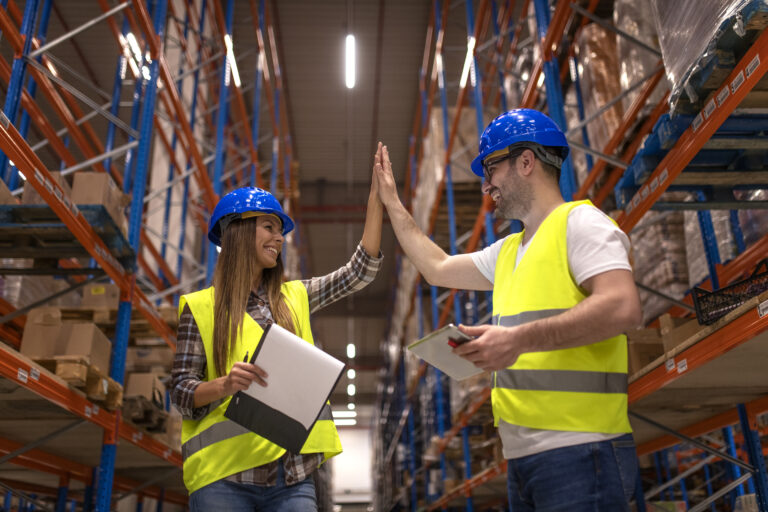 Warehouse workers clapping hands together